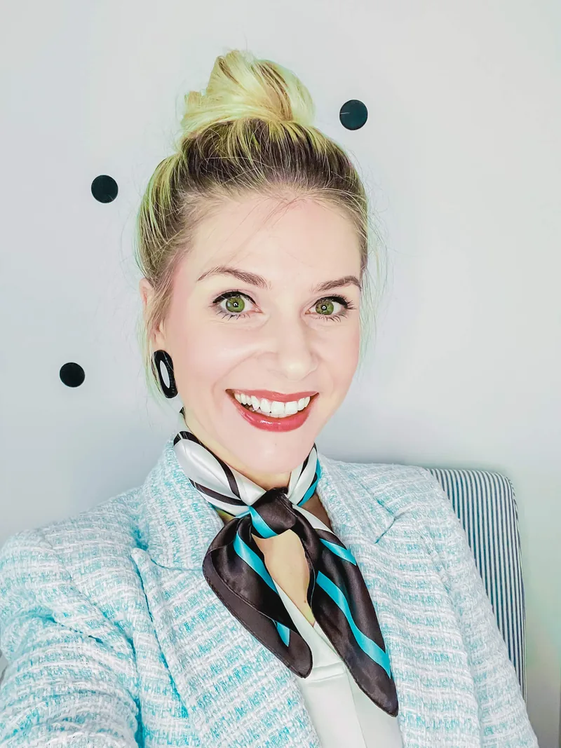 Olga Kairienė šypsosi, ant kaklo – firminė skarelė