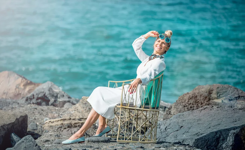 Olga sėdi prie jūros ir šypsosi